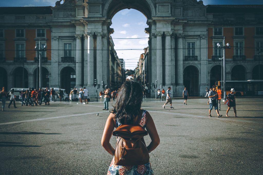 Woman visiting Lisbon. People from behind.