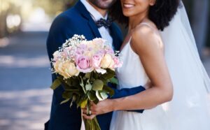 Flowers, wedding and marriage with a bride and groom posing outdoor for a photograph at their celeb