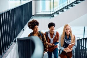 Multiracial group of happy college students in a hallway.