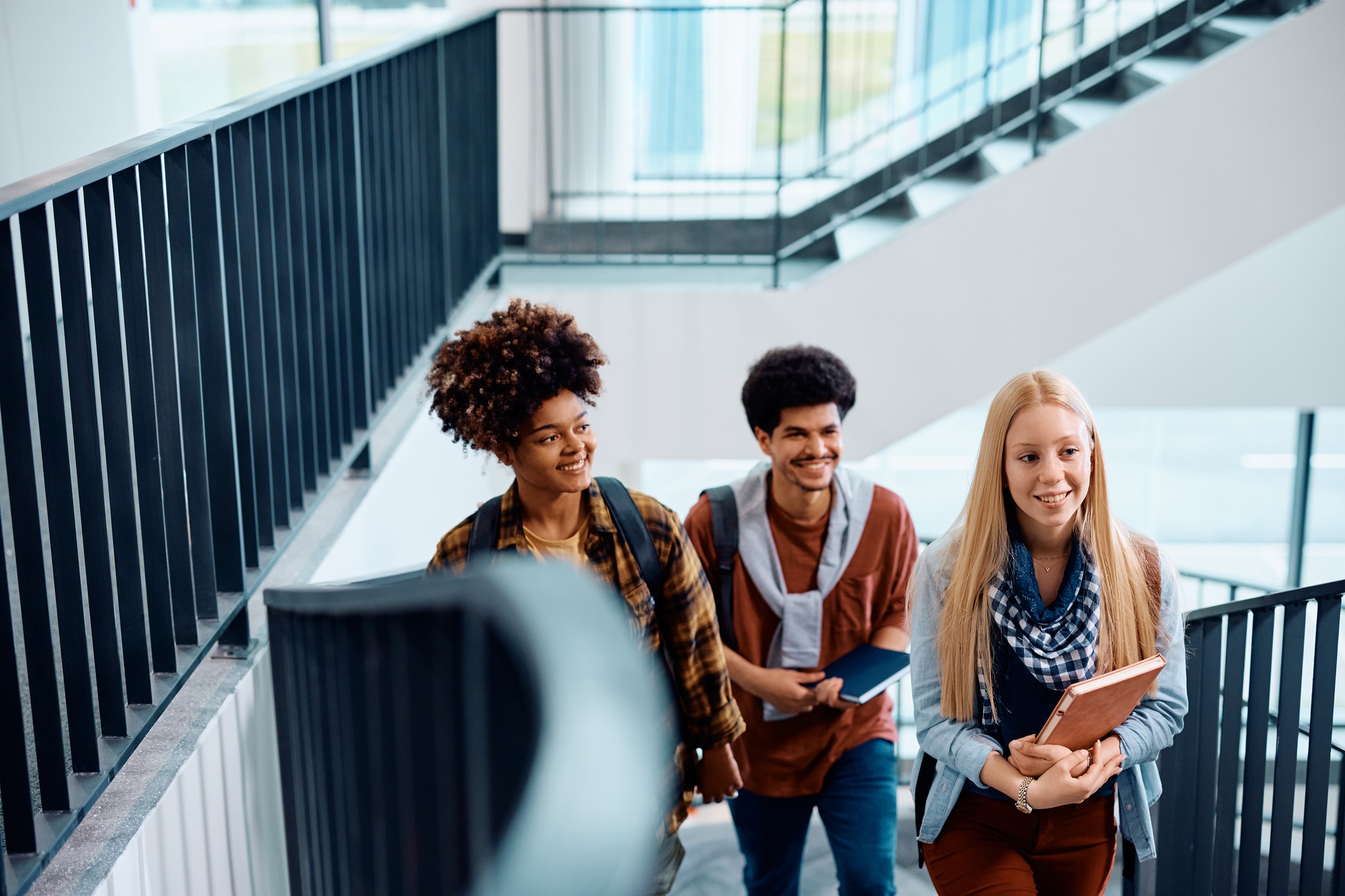 Multiracial group of happy college students in a hallway.
