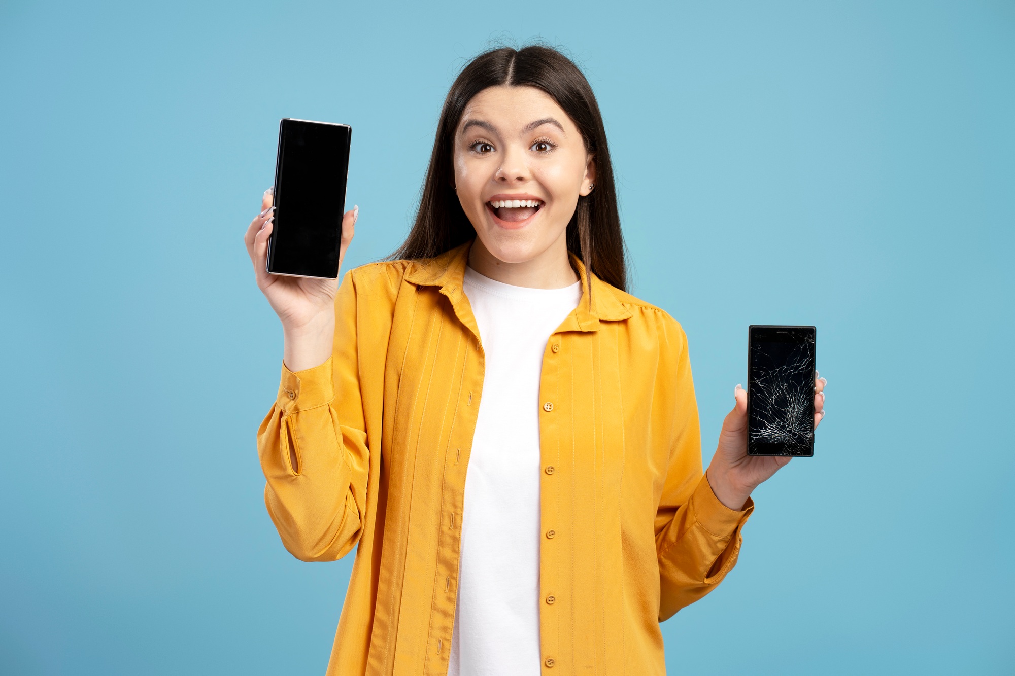 Woman showing new smartphone and broken one, comparing mobile phones