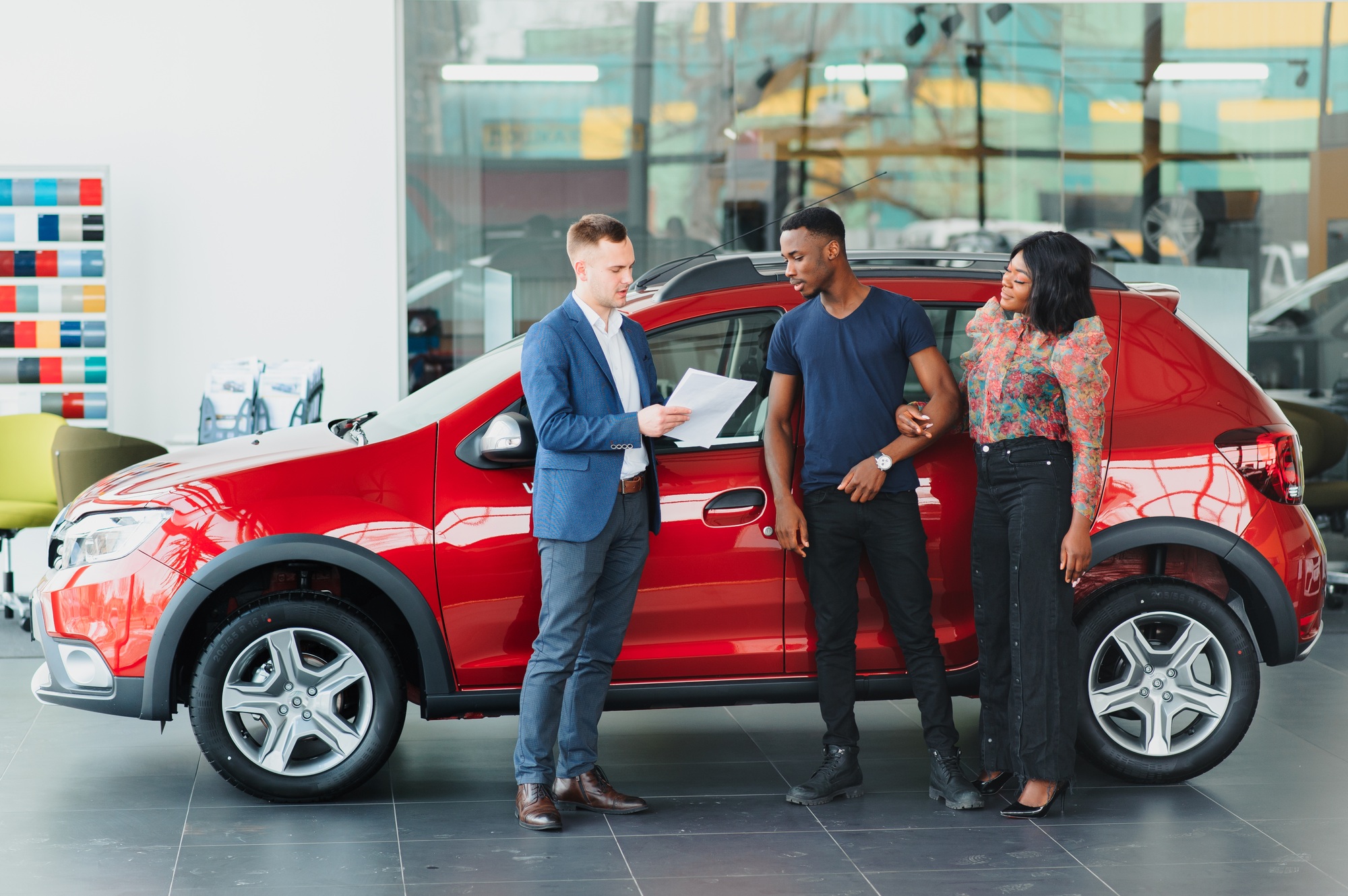 young african couple buying new car at dealership
